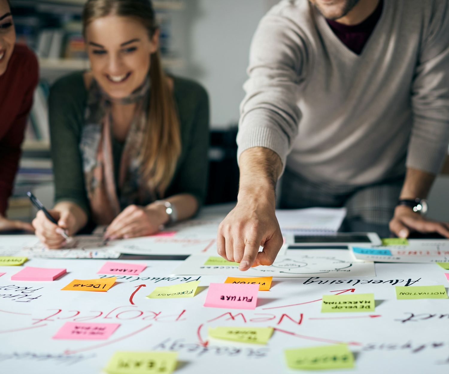A team working together around a table covered with plans and sticky notes